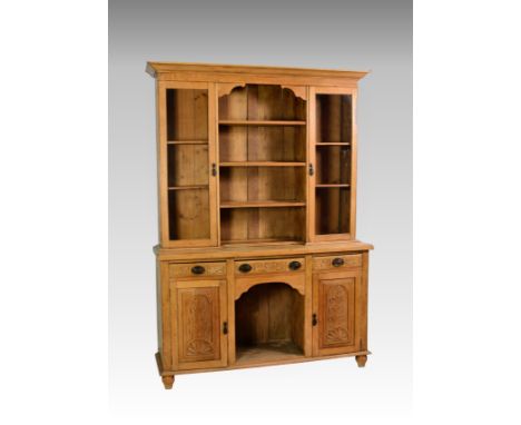 A late Victorian light oak dresser, the flare cornice over a part glazed and shelves closed back, the base with three drawers