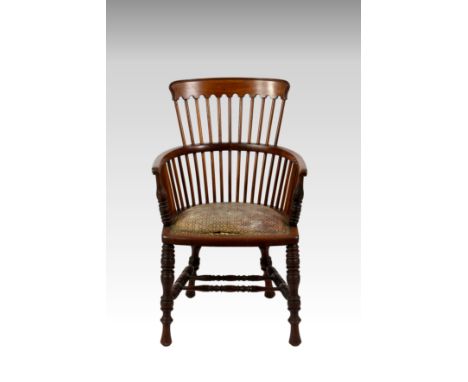 A late Victorian walnut Windsor style chair, the comb back over U-shaped arms on ring turned supports and a D-shaped seat wit