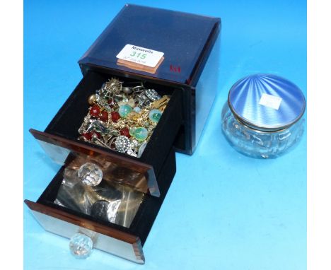 A silver and blue enamel top trinket jar; a peach glass 2 drawer jewellery cabinet and costume jewellery