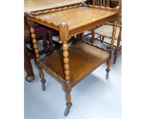 A golden oak 2 height tea trolley on bobbin legs
