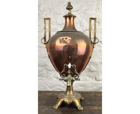 Victorian brass and copper Samovar, urn shaped body with flaming torch finial, brass tap and similar feet, H55cm 