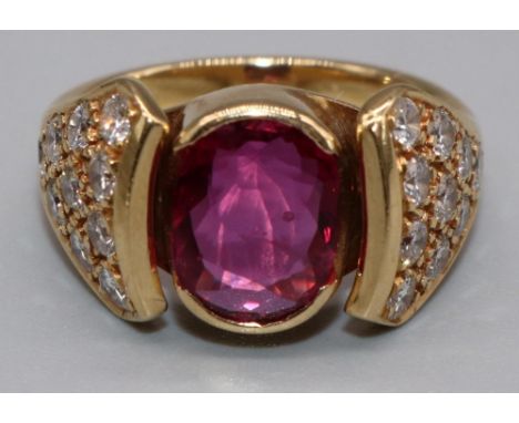 18ct yellow gold diamond and ruby ring by Susan Wright, the central oval cut ruby in split bezel mount, on tapered diamond se