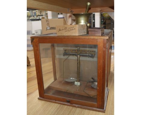 A cased set of beam scales and weights, a pestle and mortar and a student's microscope