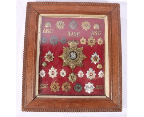 Framed display of approximately 32 Army Service Corps ASC cap badges, collar badges, shoulder titles etc., including a helmet