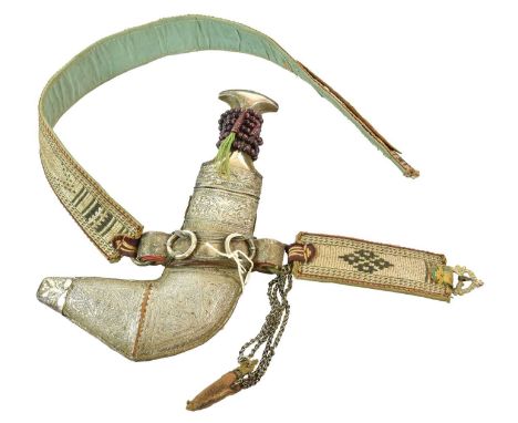 An Early 20th Century Omani Khanjar, the 17cm double edge curved steel blade with raised medial ridge, the horn grip with sil