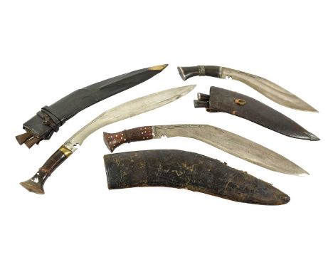 A Small Kukri, the 23cm curved steel blade with chiselled decoration to the back edge, the horn grip with silver bolster, fol