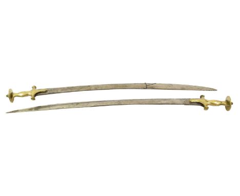 Two Late 19th Century Indian Tulwars, each with 75cm curved steel blade, double edged towards the tip, the brass hilt with sh