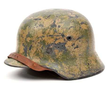 A Third Reich M40 steel helmet, with original liner bearing owner’s name, and leather chinstrap dated 1944, the skull repaint