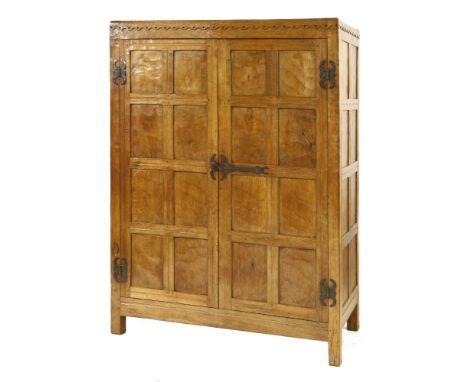 A Robert ‘Mouseman’ Thompson oak wardrobe, c.1930, with the dot and halfpenny carved frieze over an adzed and panelled case, 