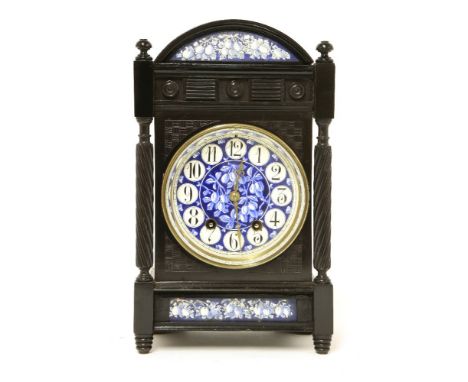An Aesthetic ebonised and enamelled mantel clock,after a design by Lewis Day, the enamelled dial centred with plums and Arabi