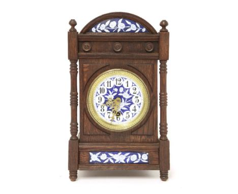 An Aesthetic oak and enamelled mantel clock,after a design by Lewis Day, the enamelled dial centred with flowers and Arabic n