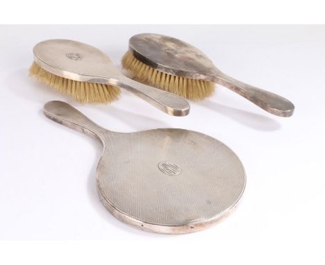 George VI silver dressing table set, London 1947, maker TP, consisting of hand mirror and two hairbrushes, the engine turned 