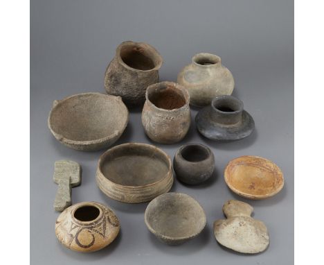 Twelve prehistoric objects including ten pieces of pottery and two stone tools. Pottery includes four bowls, including one wi