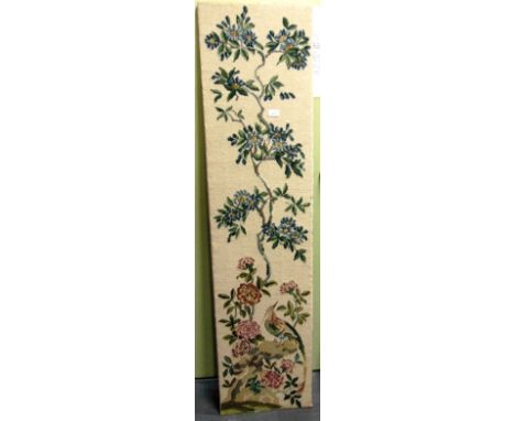 A WOOLWORK PANEL  depicting an exotic bird amidst flowering branches, 160cm x 39cm.