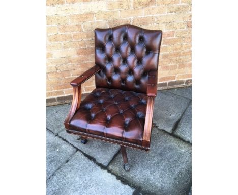 A BROWN LEATHER BUTTON UPHOLSTERED OFFICE SWIVEL ARMCHAIR  (the casters replaced)