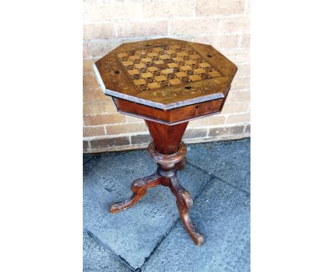 A VICTORIAN WALNUT WORK/GAMES TABLE  the octagonal top inlaid with chessboard opening to fitted interior, on carved tripod ba