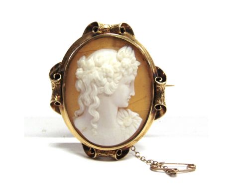 A VICTORIAN SHELL CAMEO BROOCH the oval female profile carved panel to an unmarked frame with parchment scrolls to the quarte
