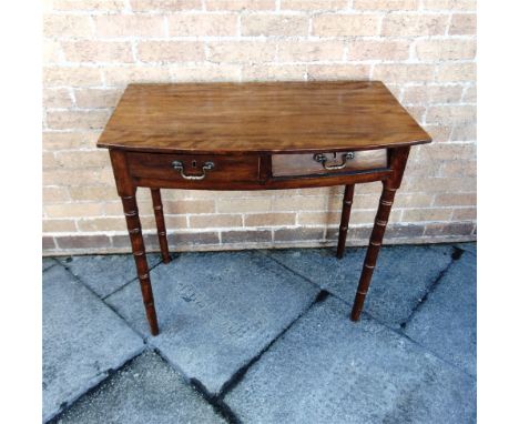 A BOW FRONT SIDE TABLE  fitted with two drawers on turned faux bamboo supports (a/f), 84cm wide 49cm deep 73cm high