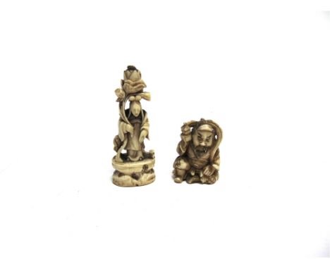 A JAPANESE IVORY NETSUKE  carved as a seated man holding a box or casket, 4.75cm high; together with another carved ivory fig