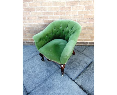 A LATE VICTORIAN BUTTON UPHOLSTERED TUB ARMCHAIR  on carved cabriole supports with brass casters, 70cm wide 70cm high 70cm de