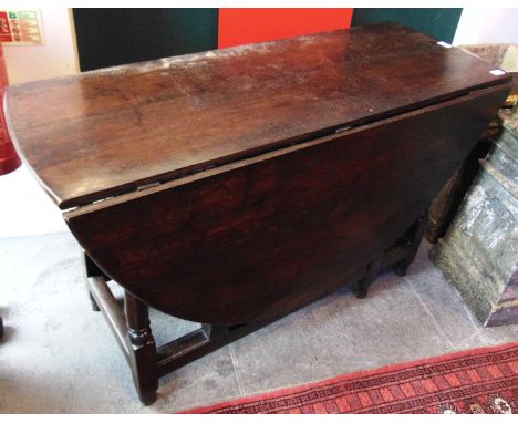 AN OVAL OAK GATELEG DINING TABLE  fitted with drawer to one end, on turned baluster supports, 120cm deep 48cm wide (150cm wit