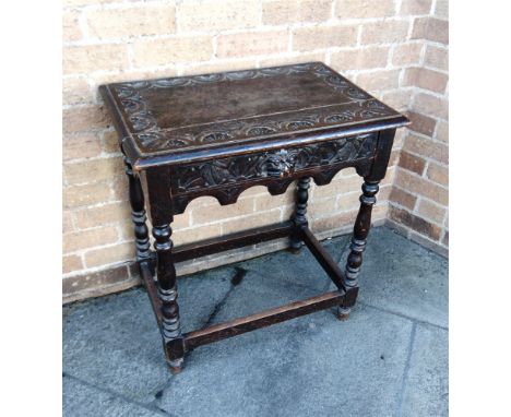 A CARVED OAK HALL TABLE  the top carved with lunettes, with lion mask frieze drawer and turned supports with stretcher base, 