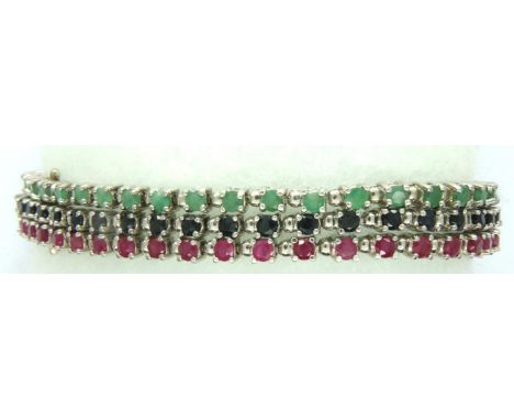 Sterling silver three strand bracelet set with rubies, sapphires and emeralds. P&amp;P Group 1 (£14+VAT for the first lot and