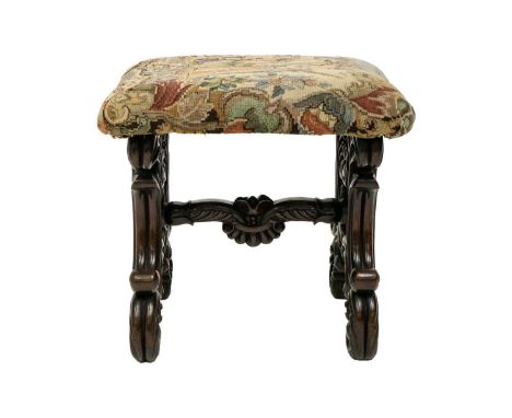A continental walnut stool. 19th century, with a padded top, on leafy scroll and foliate carved supports and stretcher, heigh