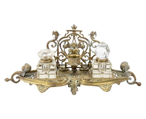 An ornate Victorian brass inkstand. The pen rest with cherub and griffin pierced decoration, with winged cherub supports, fit
