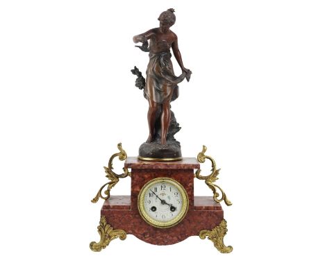 A French rouge marble and spelter mantel clock. Late 19th century, mounted a figure of a lady holding a bird, with floral pai