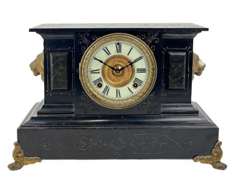An American Ansonia black lacquered iron mantel clock. Late 19th century, with lion mask mounts and white chapter ring, width