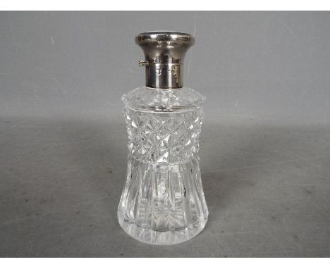 A hallmarked silver and cut glass dressing table scent bottle with enamel decorated top, hallmarks unclear.