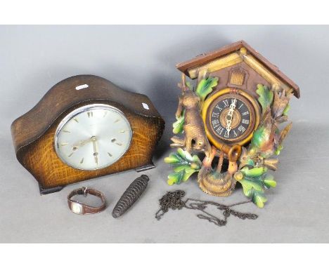 A cuckoo clock and an oak cased mantel clock.