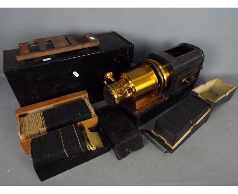 A late 19th century magic lantern, the lamp marked Stock Patent, contained in original tin box and three boxes of slides, arc