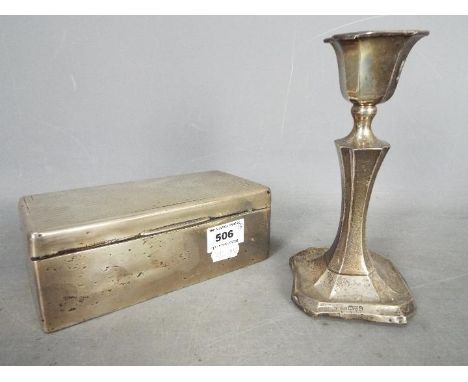 A hallmarked silver cigarette box with engine turned decoration (hallmarks unclear) and a silver candlestick (weighted), Ches