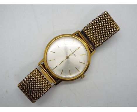 An 18ct gold cased Walker & Hall ultra slim wristwatch, the case back marked 2502G, on expanding Tessuflex gold plated strap,