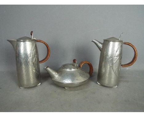 Archibald Knox for Liberty & Co - Three pieces of Tudric comprising coffee pot, teapot and hot water jug decorated in relief 