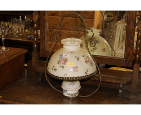 A brass and glass hanging oil lamp with floral decoration