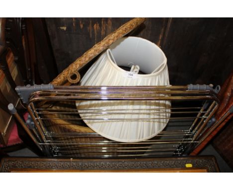 A loom corner linen basket containing a table lamp and a clothes airer