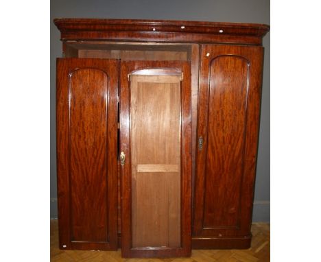 A Victorian mahogany wardrobe press, the moulded cornice over panelled doors enclosing three linen trays, two short and two l