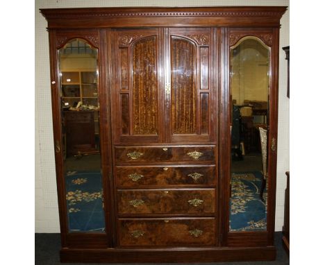 A late Victorian, three section mirror door compactum wardrobe fitted a central bank of drawers. Raised on a plinth base.190c