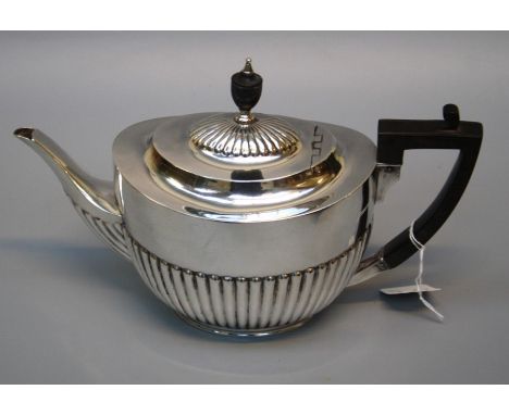 William Hutton and sons Ltd., an Edwardian silver teapot of demi gadrooned form with bakelite angular handle and urn finial. 