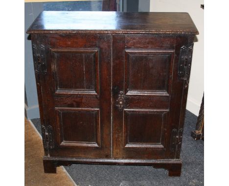 A late 17th/early 18th century oak two cupboard with two moulded panel doors.Raised on shaped bracket supports.75cm wide