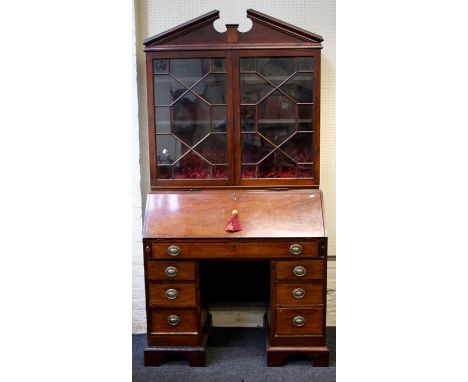 A Geo.III and later mahogany bureau bookcase, the broken architectural pediment over a pair of astragal glazed doors and fitt