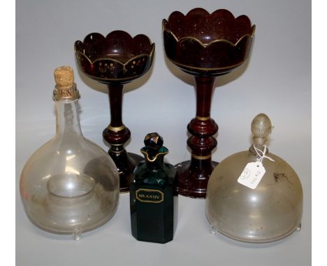 Two Edwardian glass wasp traps, two unmatched ruby glass table lustres (lacking drops) and an early 19th century green glass 