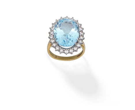 BLUE TOPAZ AND DIAMOND CLUSTER RING, 1989The oval-cut topaz within a brilliant-cut diamond surround, mounted in 18 carat gold
