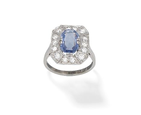 SAPPHIRE AND DIAMOND CLUSTER RINGThe octagonal step-cut sapphire within a brilliant-cut diamond surround, Swedish assay mark,