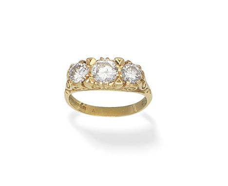 THREE-STONE DIAMOND RING, 1975Set with brilliant-cut diamonds, in an 18 carat gold mount of scrolling design, diamonds approx