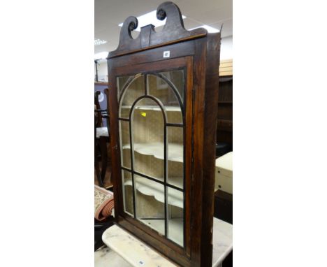 An antique three-shelf mahogany hanging corner cupboard