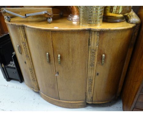 A good mid-twentieth century bow fronted railback light oak sideboard with carving & three-drawer & shelf interior